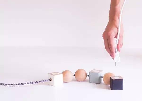 洛杉磯家具設計師 David Okum設計的ONN,把幾何圖案和插座結合到了一起。立方體既是可旋轉調整角度的插座,同時也起到穩固作用,而間隔其中的球形則是為了避免電線纏繞起來。